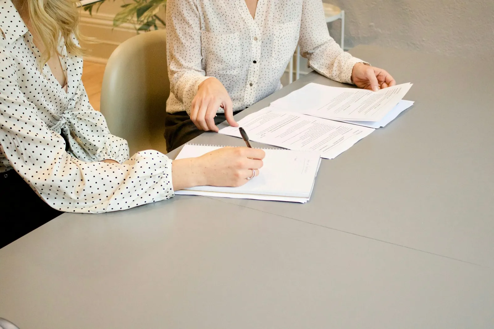 Printed documents being reviewed and notes taken at a table.