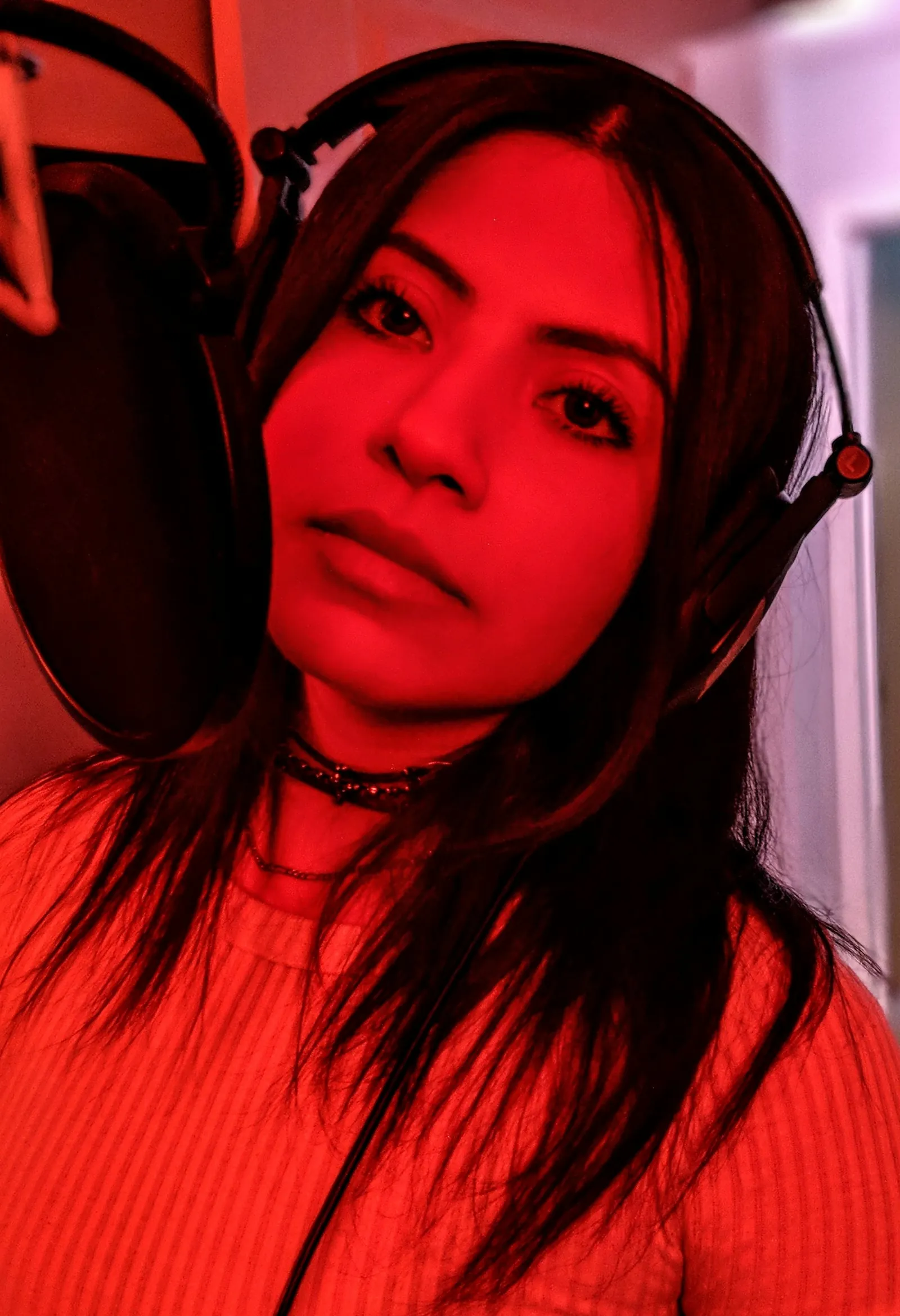 Une interprète portant un casque devant un microphone de studio.