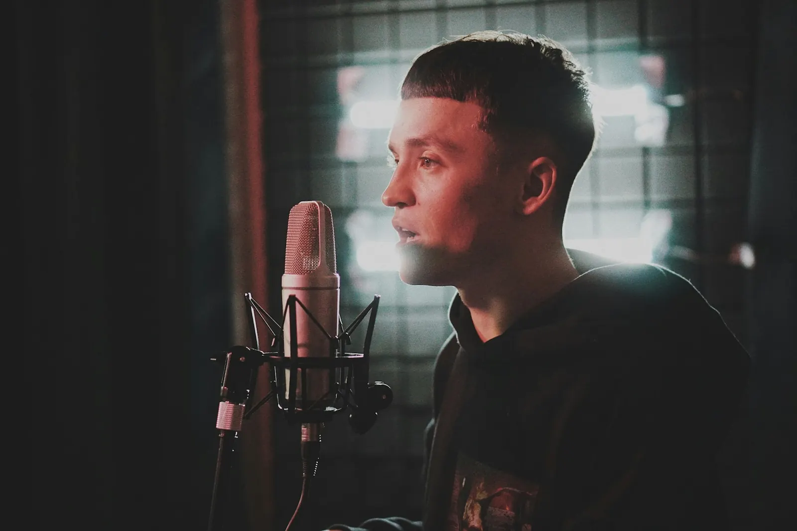 A recording artist performing into a studio microphone.